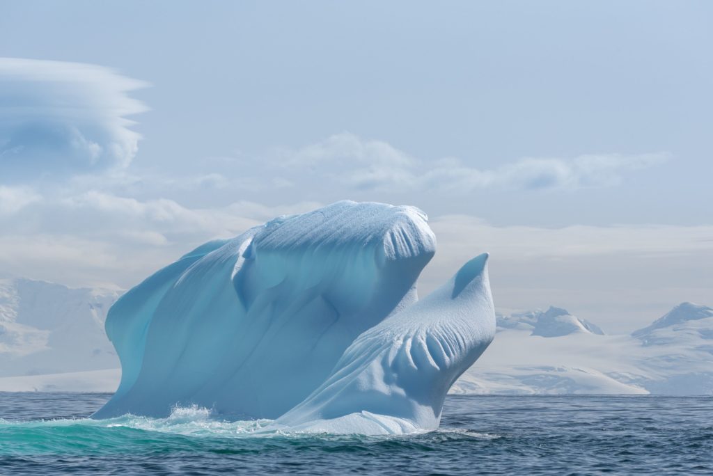 A bird like iceberg appears to be taking off out of the ocean in Antarctica