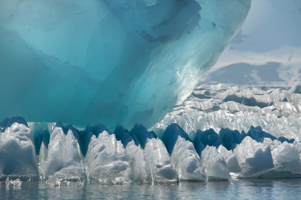 A crystal like large ice form like a giant diamond is resting on serrated ice in a bay in the Arctic