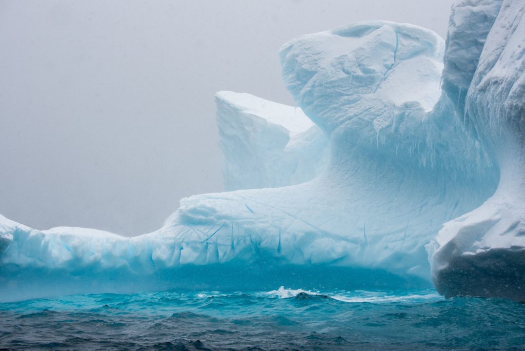 Icy blue iceberg in the watery mist