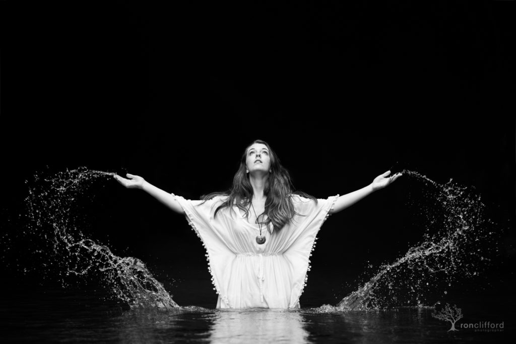 Young Woman reaching toward heaven from a stream